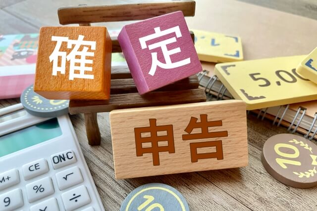 税務処理を示す木製ブロックと電卓